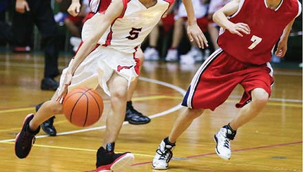 photo of highschool basketball being played, angled bodies